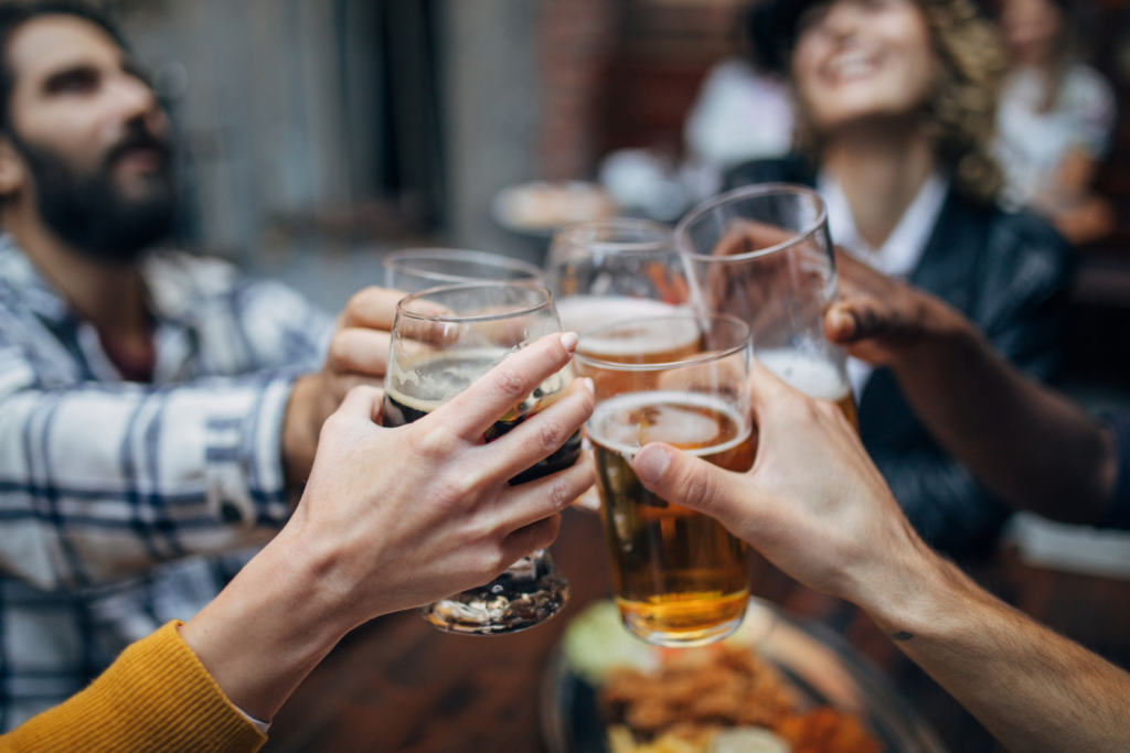 a group of friends toasting with pint glasses