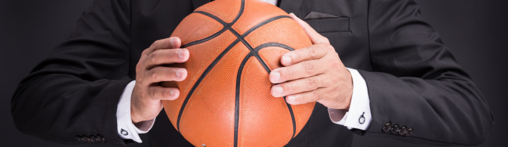 arms holding a basketball and wearing a business suit